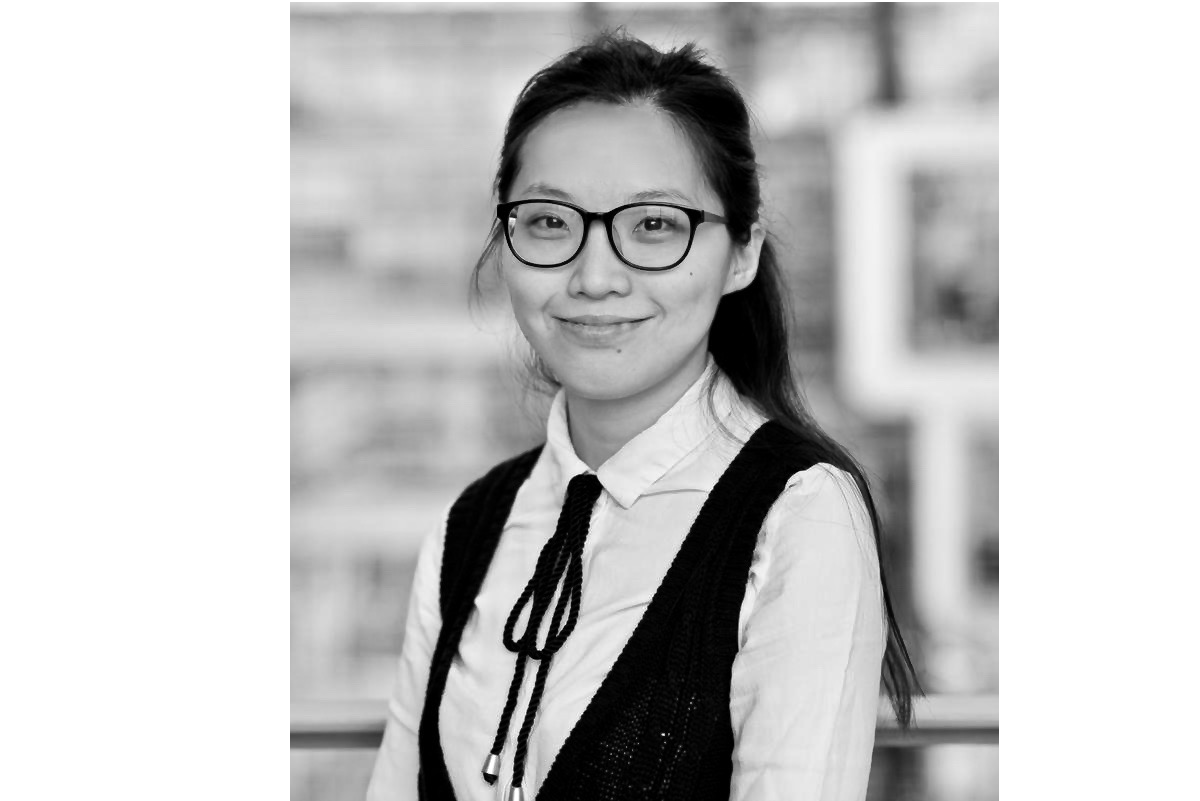 Black and white portrait of Cancan wearing black glasses a white shirt and a black west